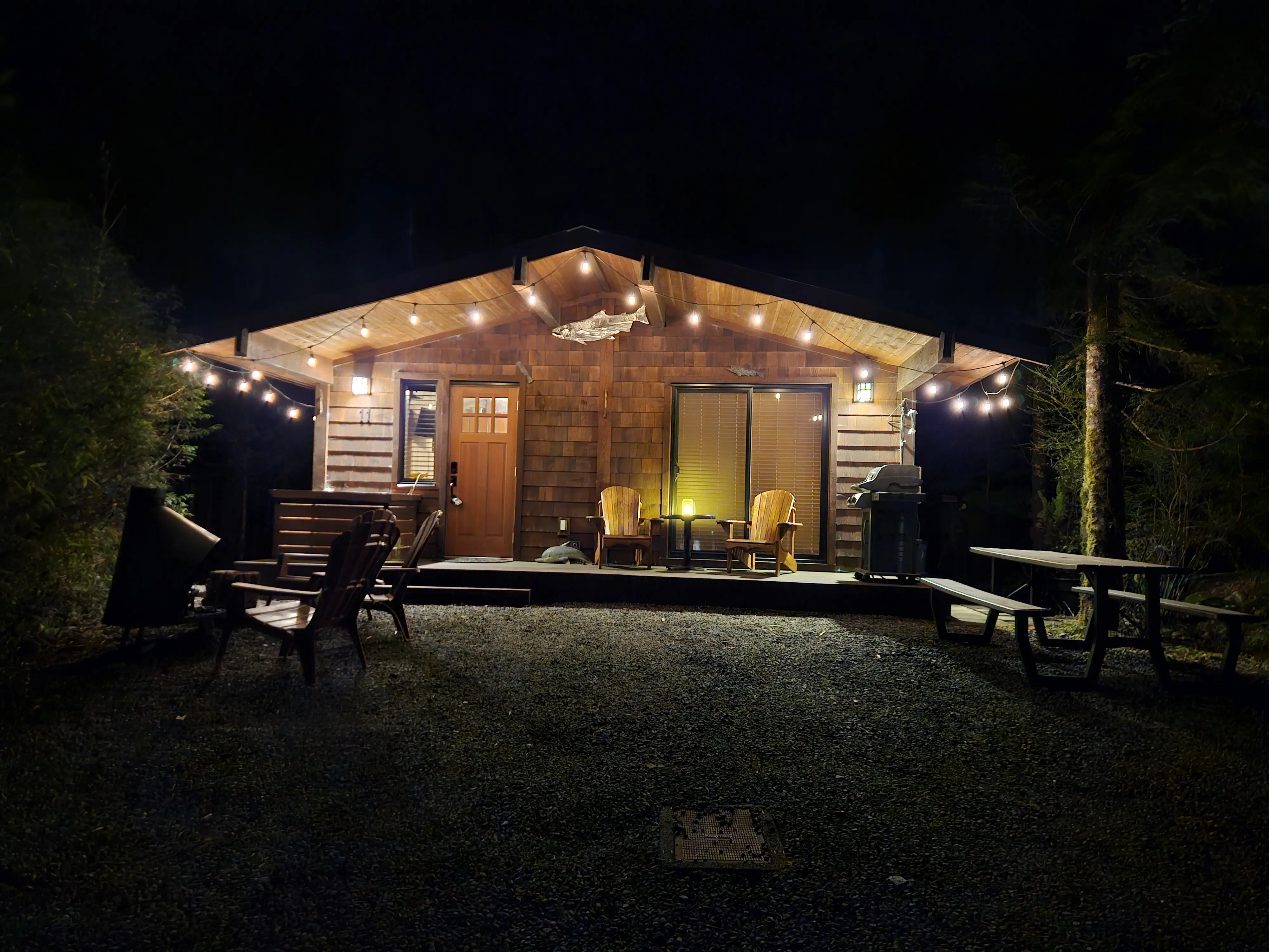 Rachael's Retreat Port Renfrew cabin front exterior with string lights at night