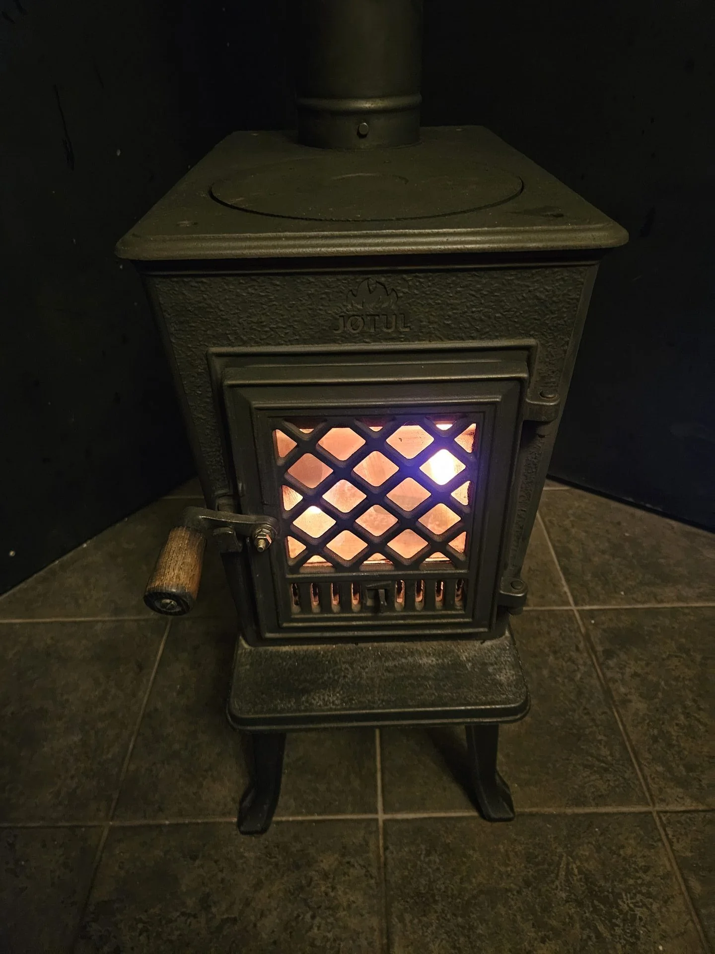 Cast iron wood stove glowing inside Rachael's Retreat Port Renfrew cabin